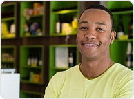 A man smiling for the camera in front of shelves.